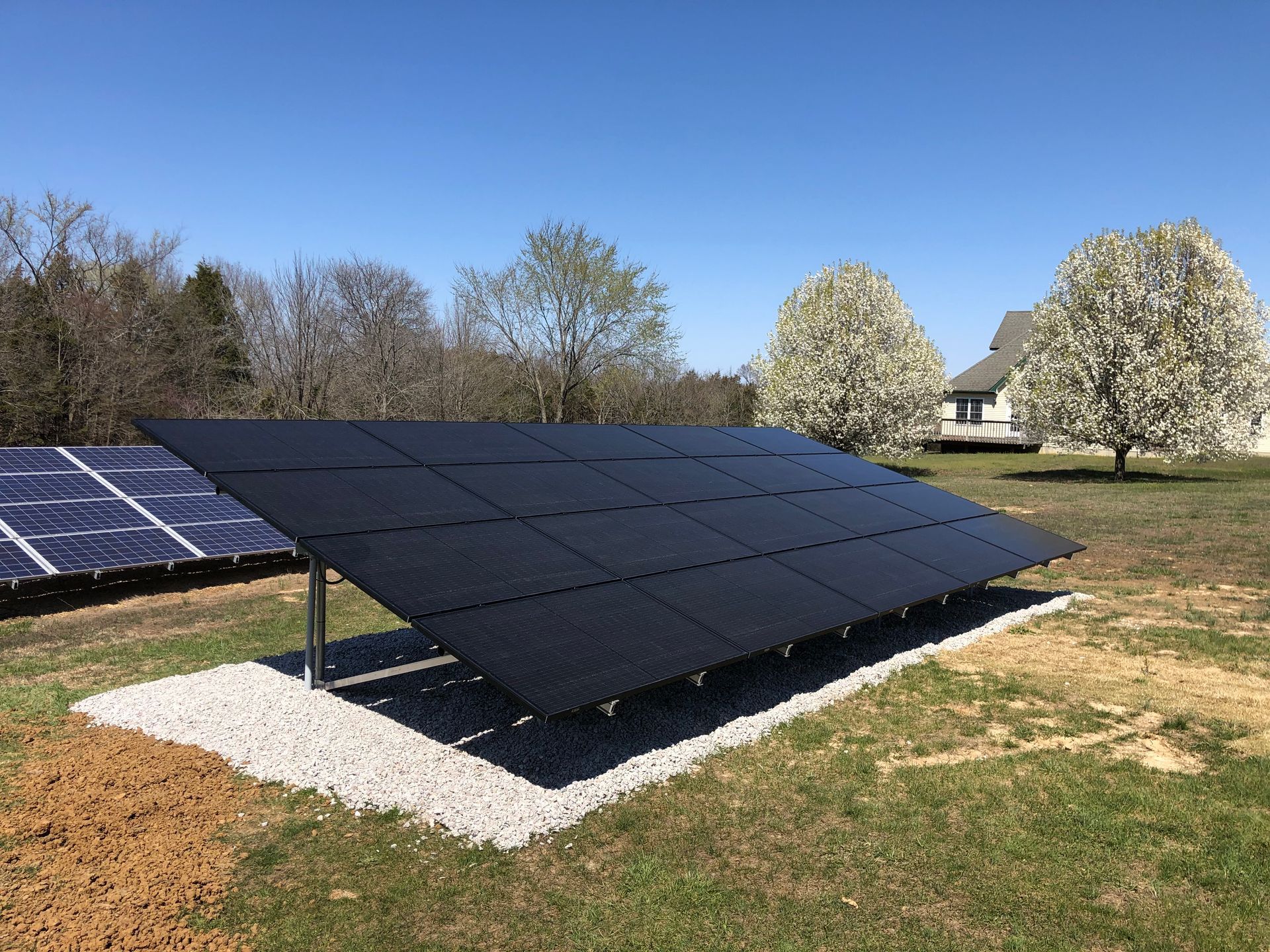 A large solar panel is sitting in the middle of a grassy field.