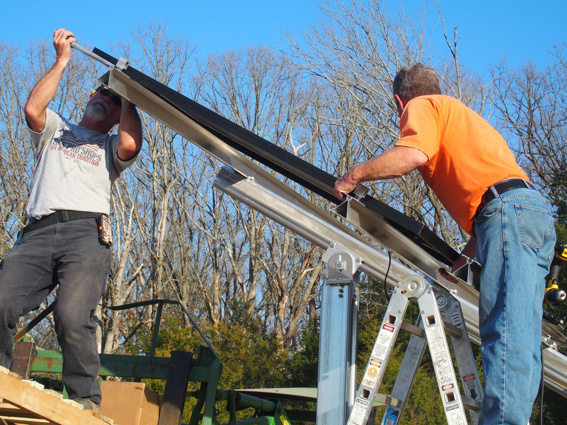 Two men are working on a solar panel on a roof