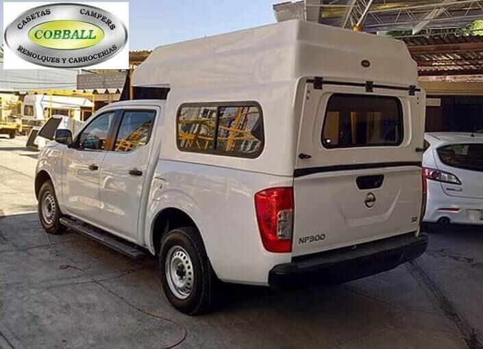 Camioneta Nissan blanca con una cubierta para la caja blanca y el logotipo de Cobball en la esquina superior izquierda.