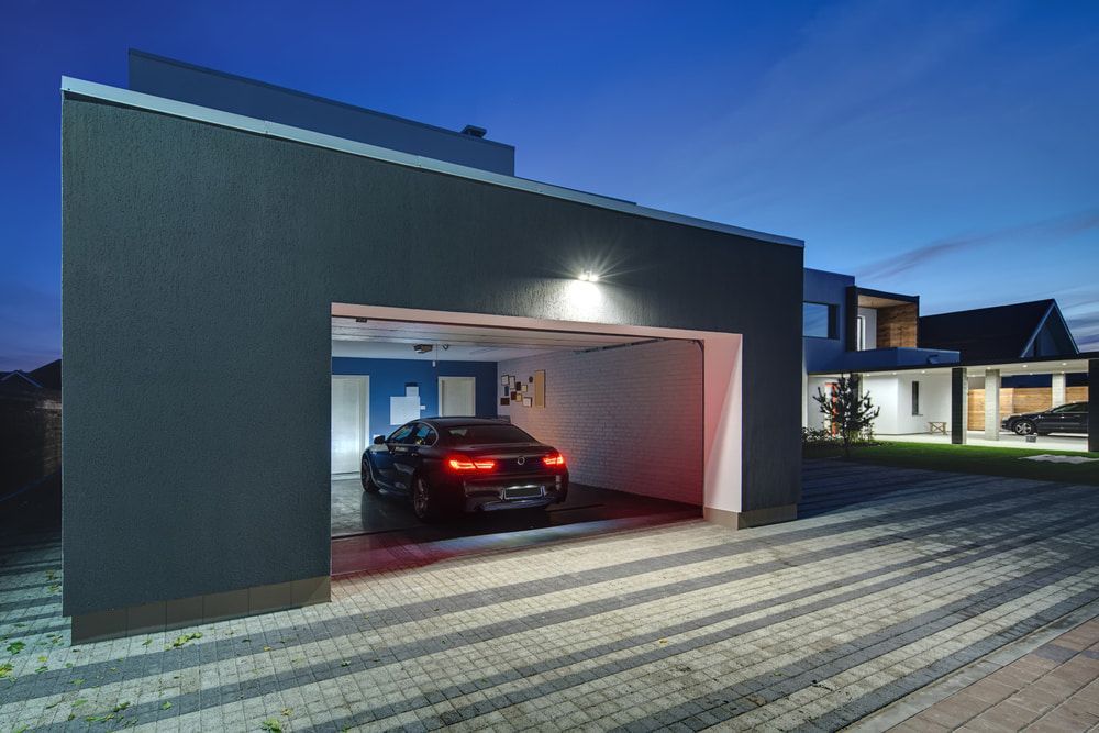 A Car Is Parked In A Garage Next To A House At Night — Taminda Smash Repairs In Taminda, NSW
