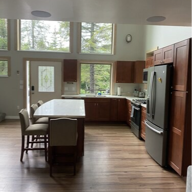 Kitchen with dark wood cabinets, island, and stainless steel appliances.