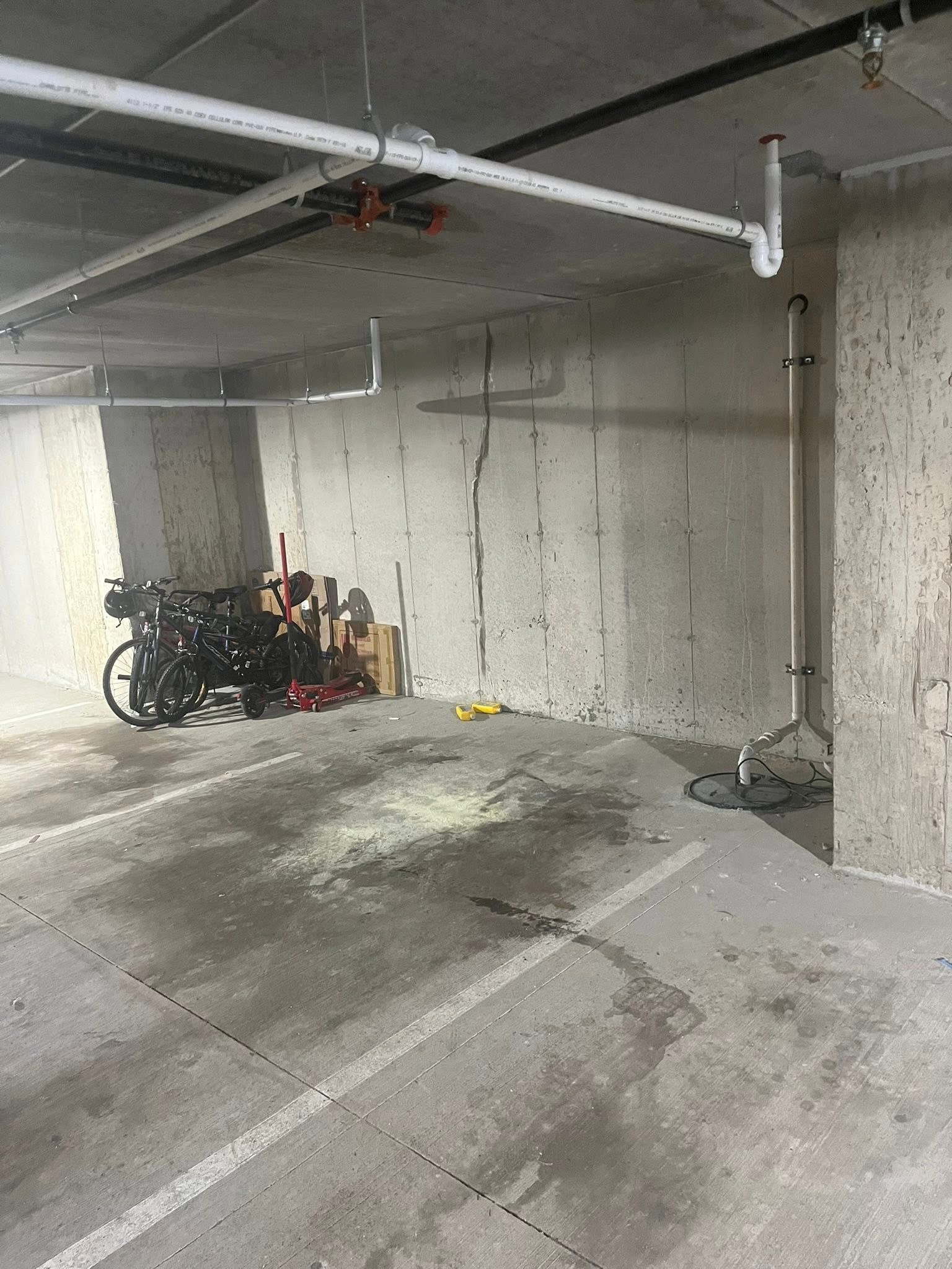 Empty concrete parking garage with a few bicycles parked against the left wall.