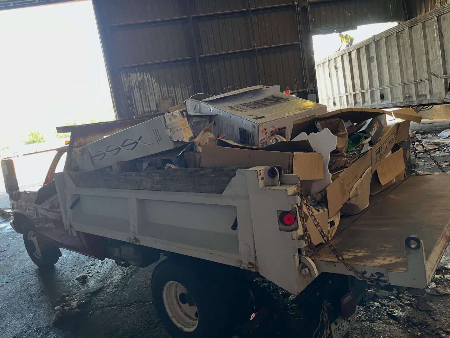 Trailer loaded with scrap metal and debris inside a covered industrial shed