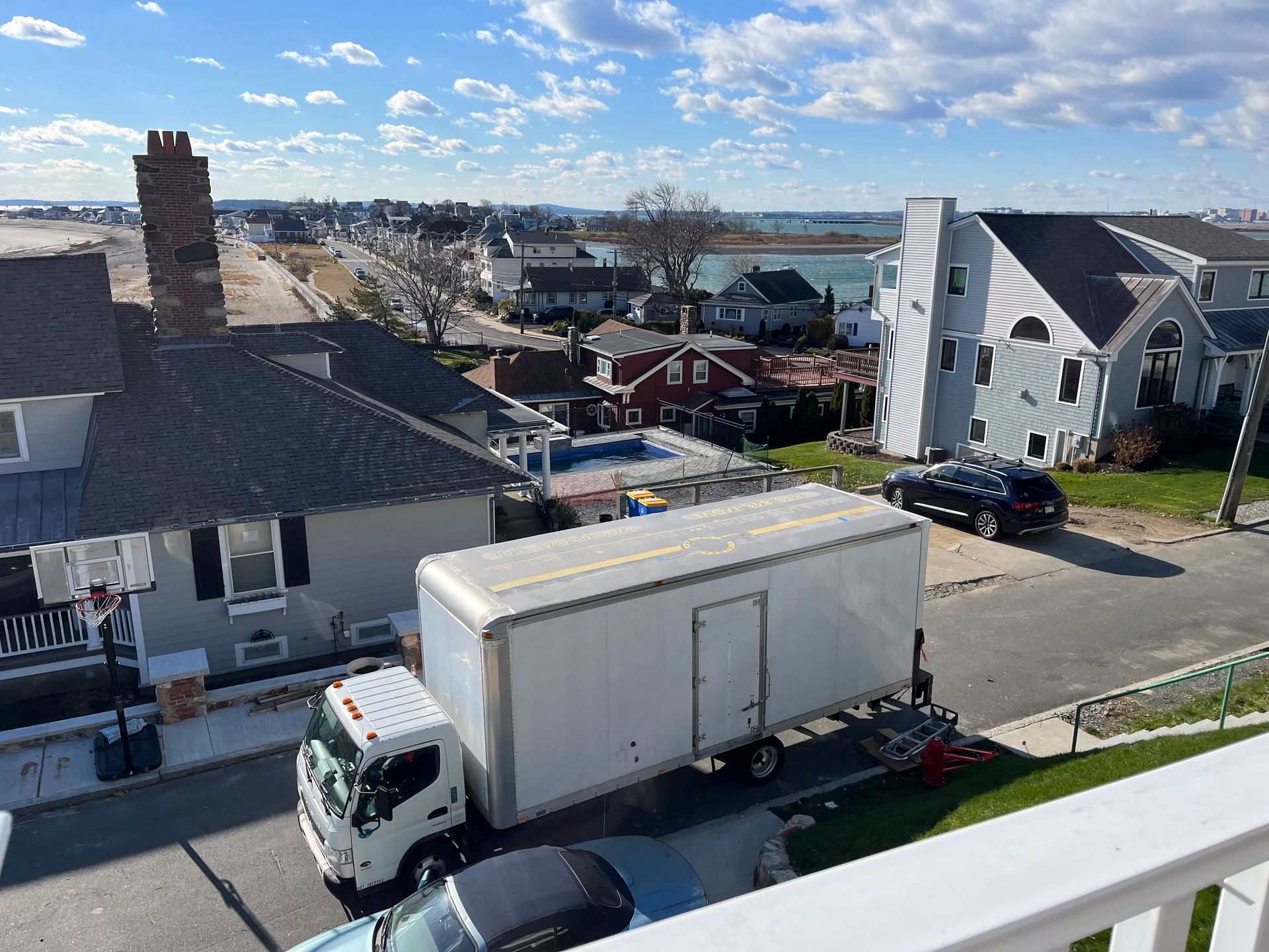 Person standing by open truck on city sidewalk, with buildings in the background.