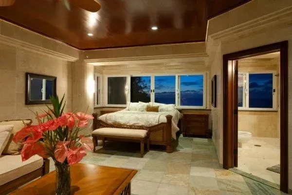 Luxurious bedroom with bed, sofa, large windows, and an open bathroom.