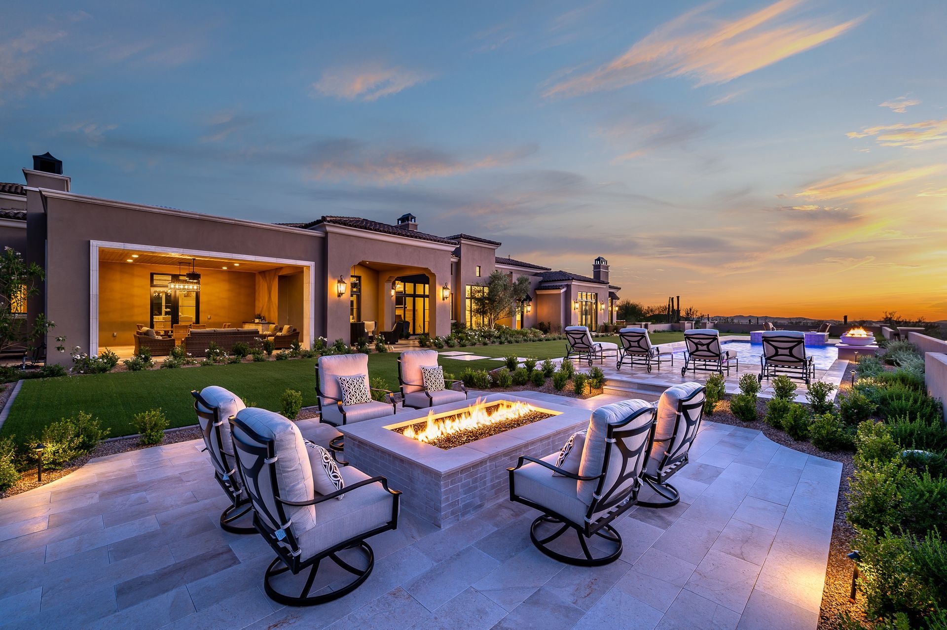 Luxury home patio with fire pit, lounge chairs, and Arizona sunset view