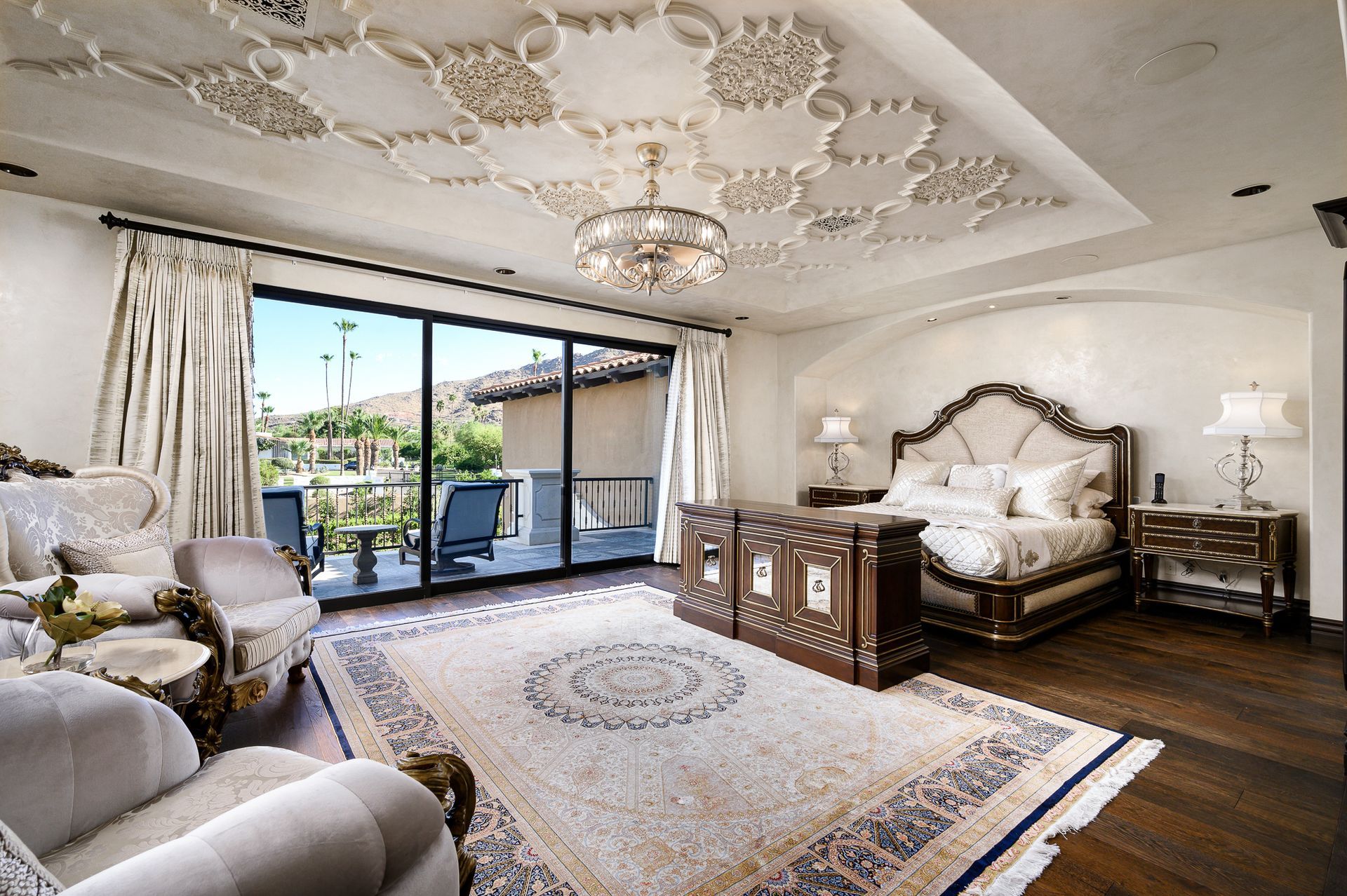Luxury primary suite with custom ceiling details, elegant furnishings, and high-end residential