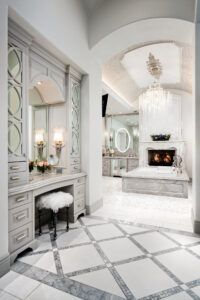 A bathroom with a vanity , stool , mirror and fireplace.