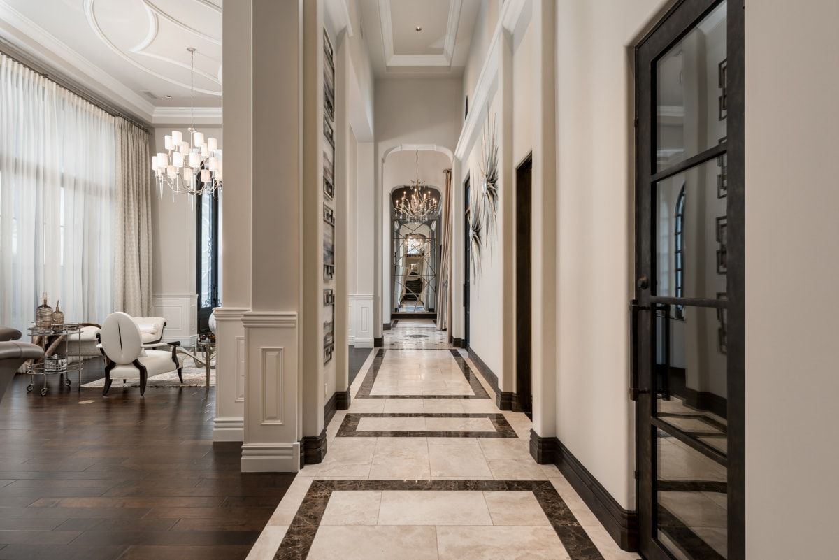 Long hallway with dark wood flooring, marble inlay, and ornate detailing.