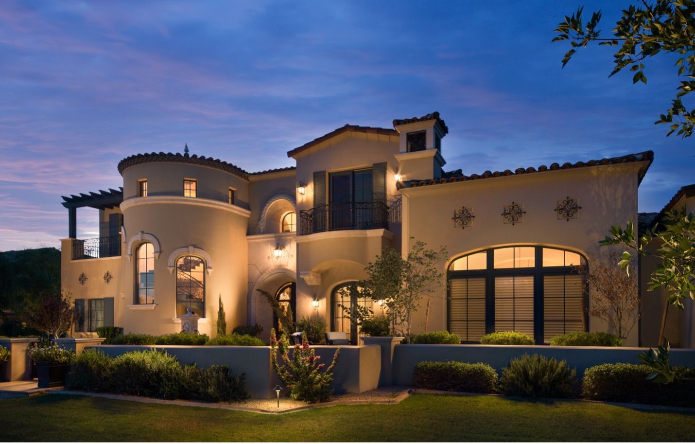 A large house with a lot of windows is lit up at night