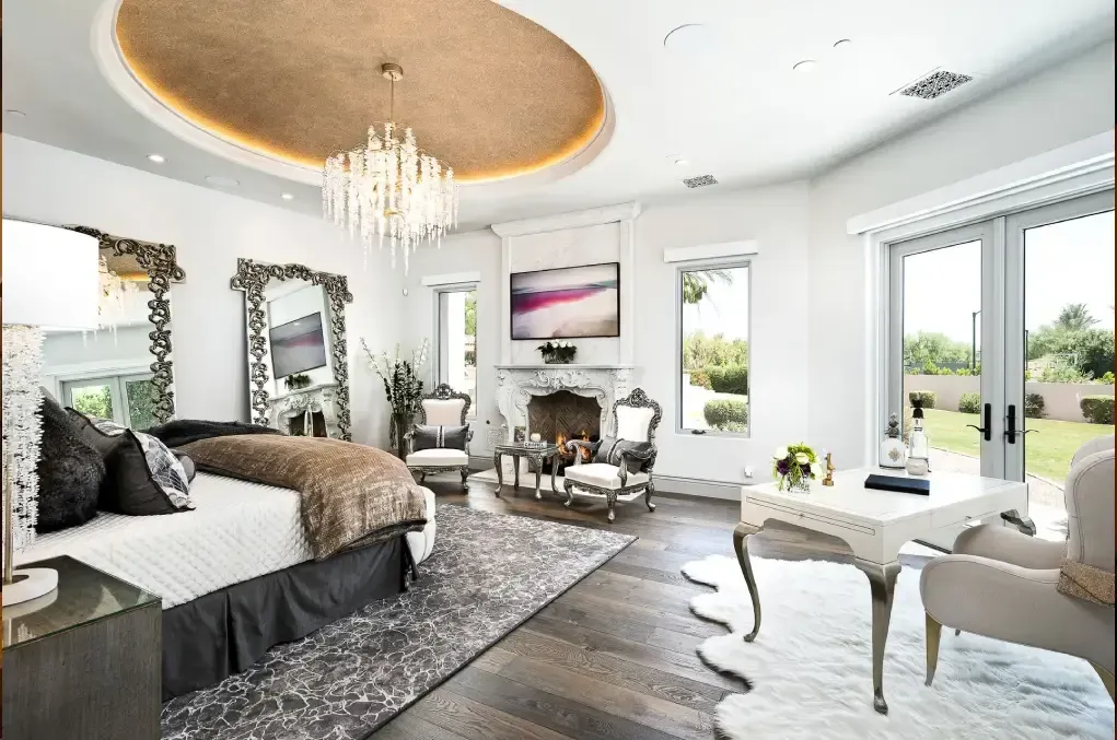 Elegant French-inspired luxury bedroom with chandelier and fireplace