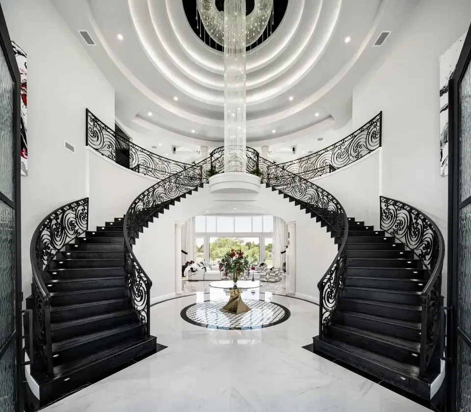 entryway with custom double staircase and crystal chandelier