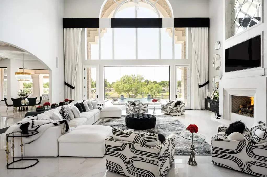 luxury modern living room with black and white furniture and large window overlooking a pool