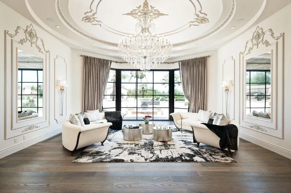 luxury living room with large window, custom ceilings and walls, furniture and chandelier
