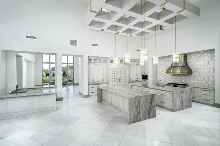Luxury white kitchen with coffered ceiling and dual marble islands