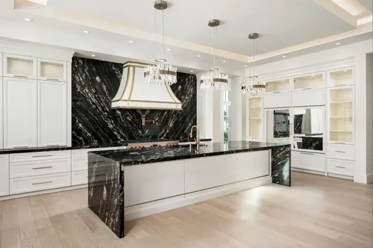 Modern luxury kitchen with black marble island and custom white cabinetry
