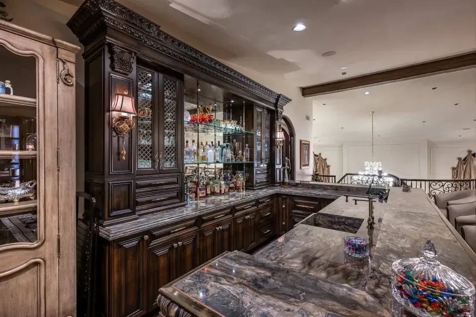 Loft with custom bar, dining table, fireplace, and wall-to-wall bookshelf