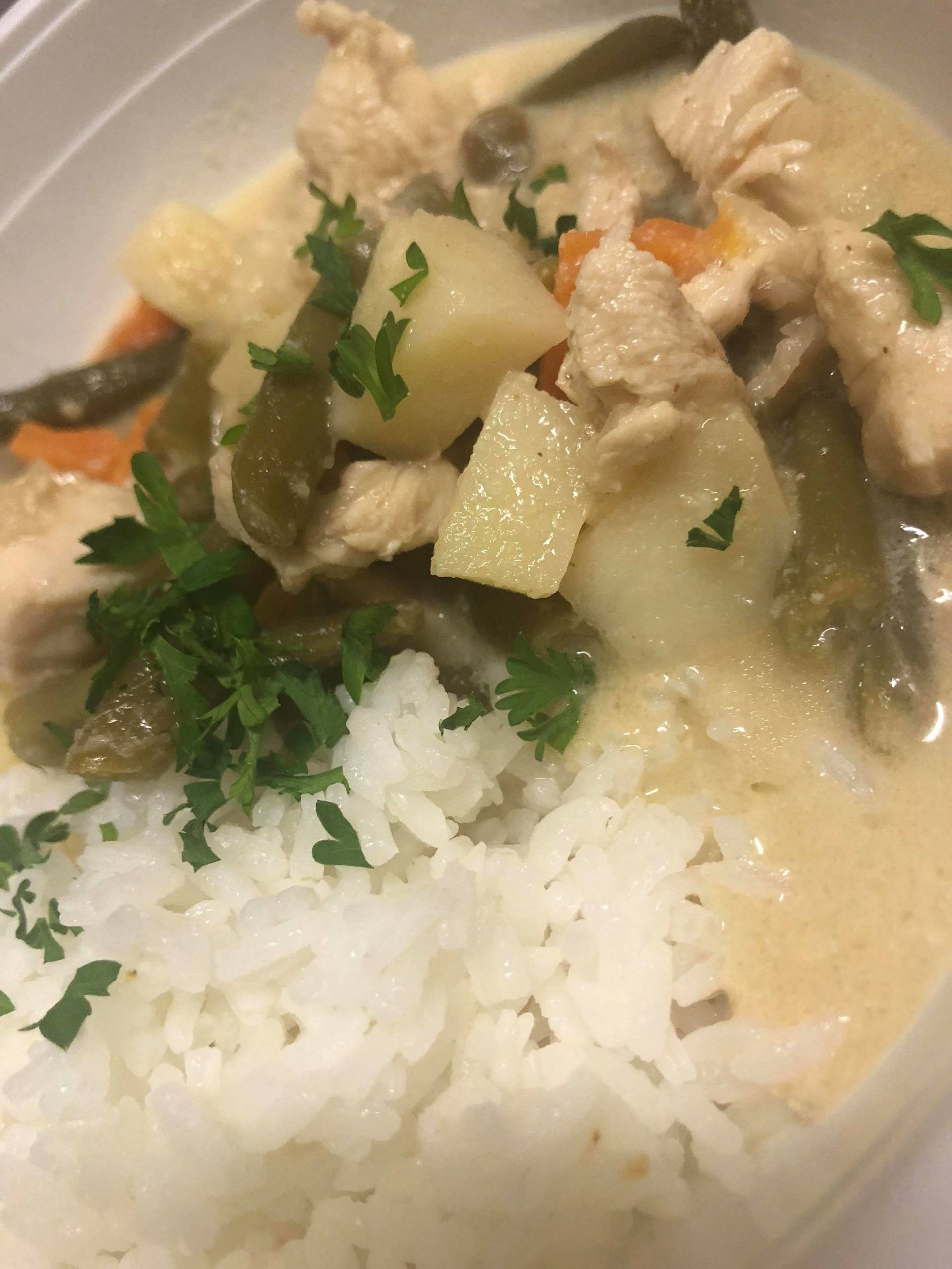 Rice with creamy chicken and vegetable stew, topped with chopped parsley.