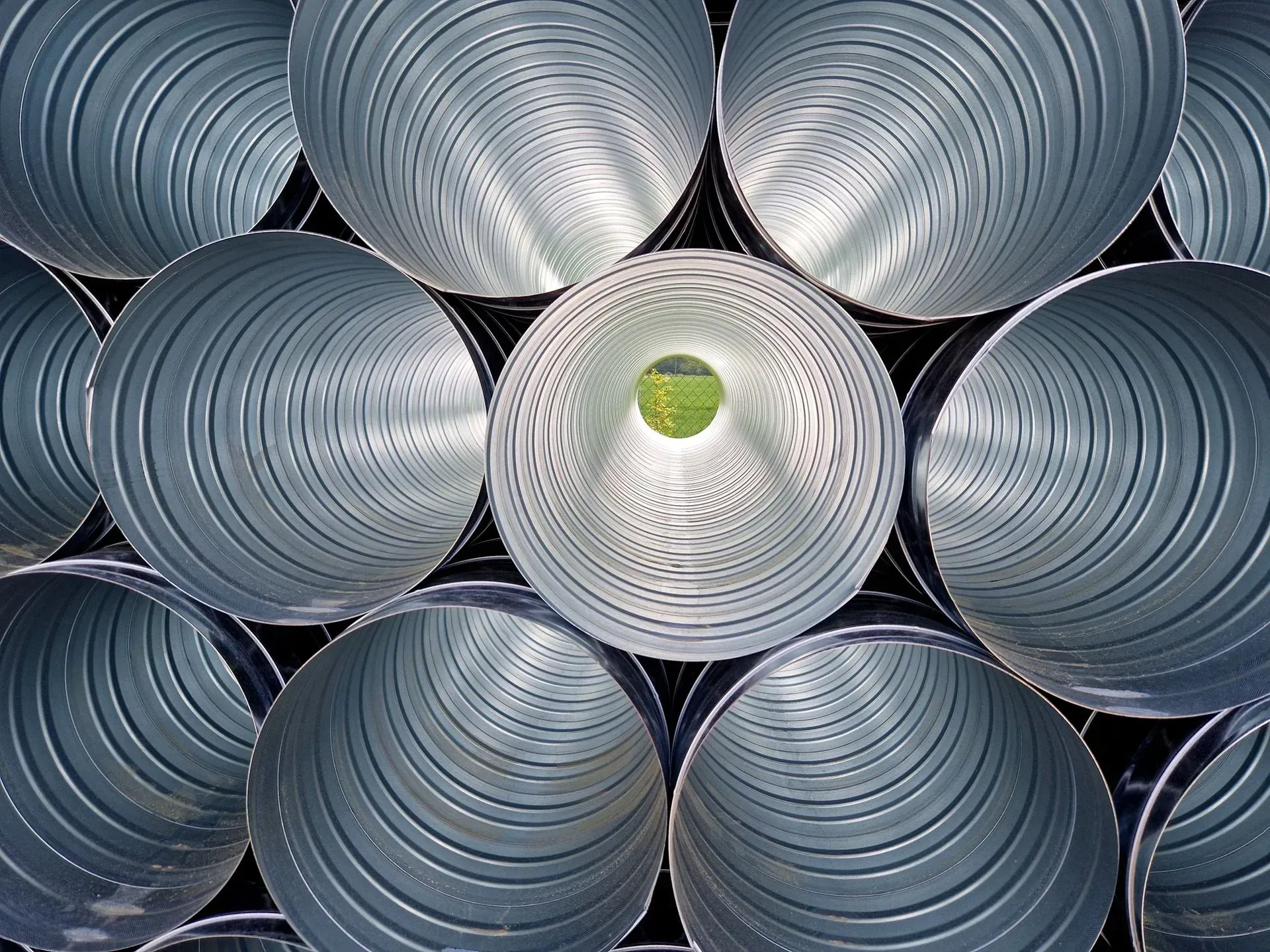 A bunch of metal pipes are stacked on top of each other.