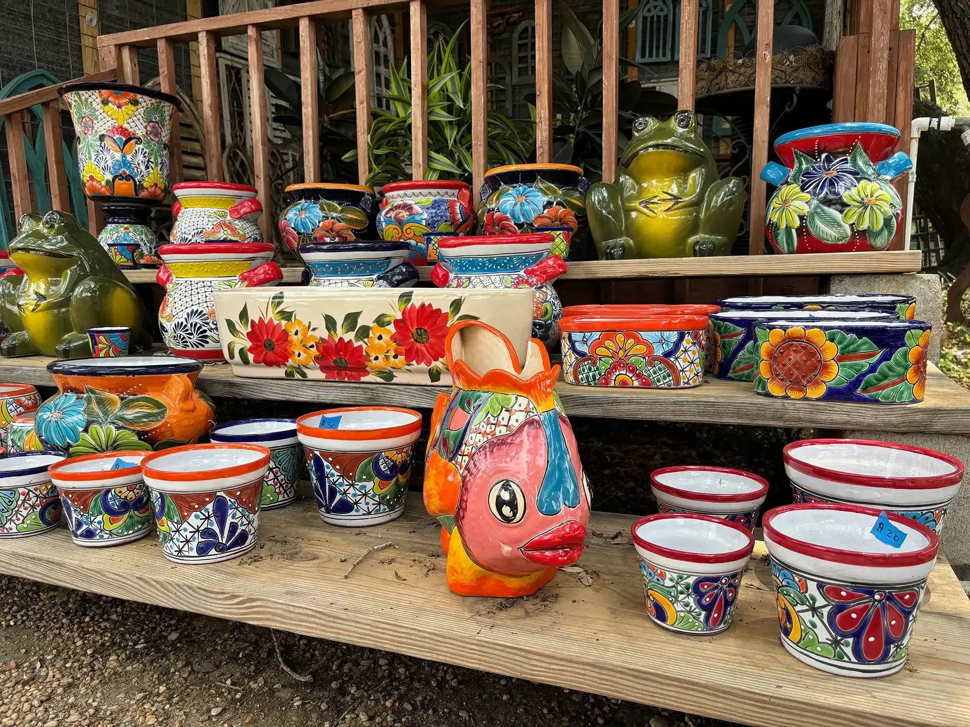 Colorful painted ceramic bowls, pots, and cups displayed on a market stall table