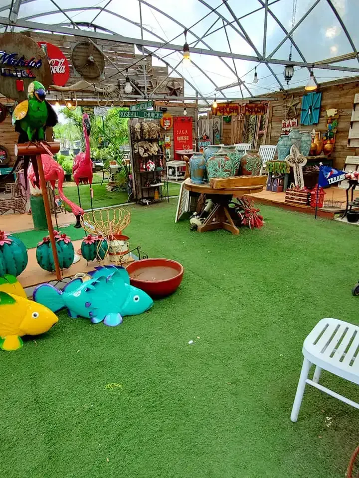 Colorful toy and craft market stall under a tent with green turf, baskets, and hanging decorations