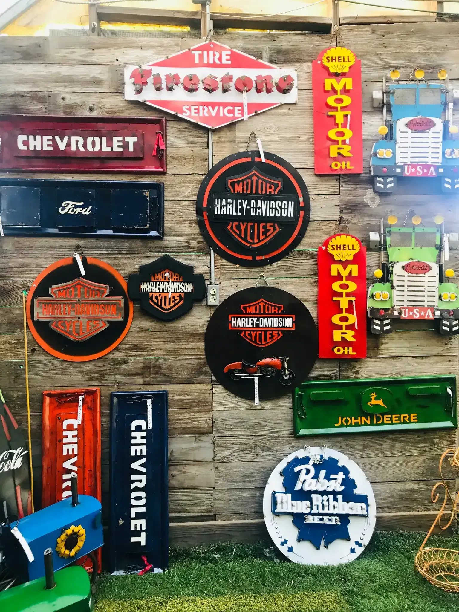 Assorted vintage Chevrolet and Texaco automotive signs on a wooden wall display