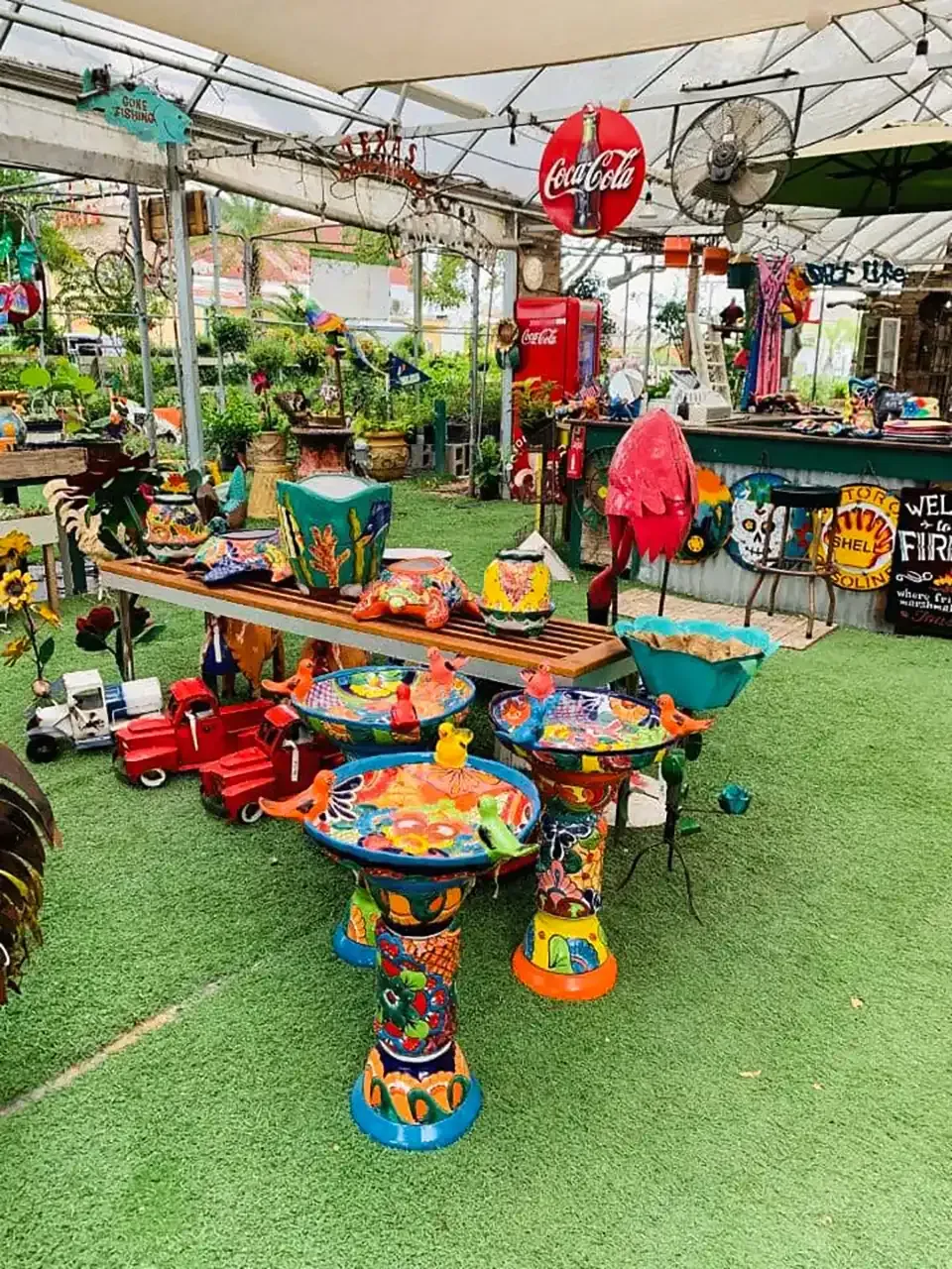 Colorful children’s play tables and benches under a canopy in an outdoor garden market