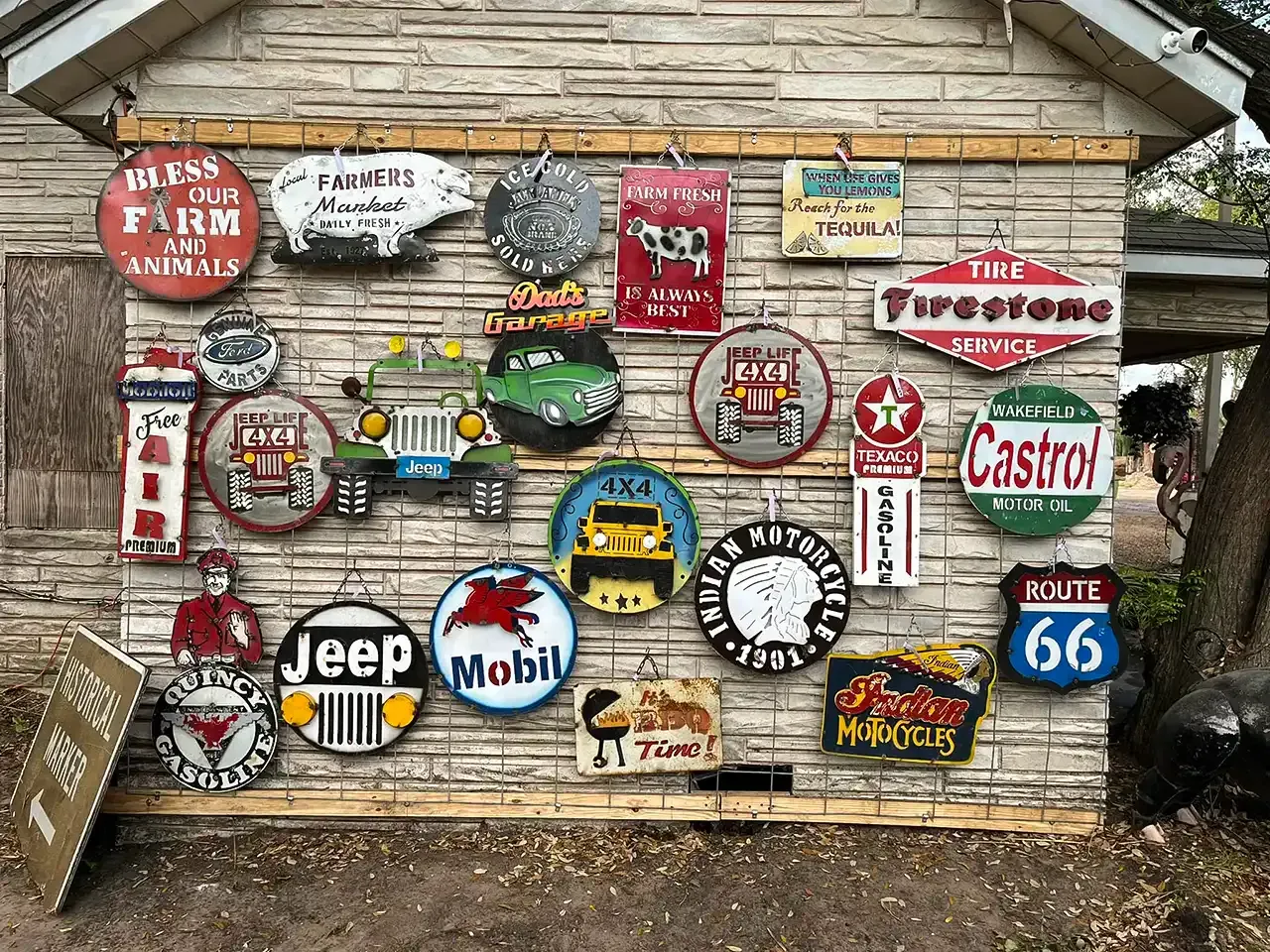 Rustic shed wall covered with colorful vintage gas, oil, and auto brand signs
