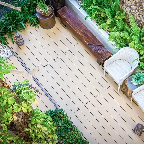 Wooden deck with seating and lush greenery in a garden setting.