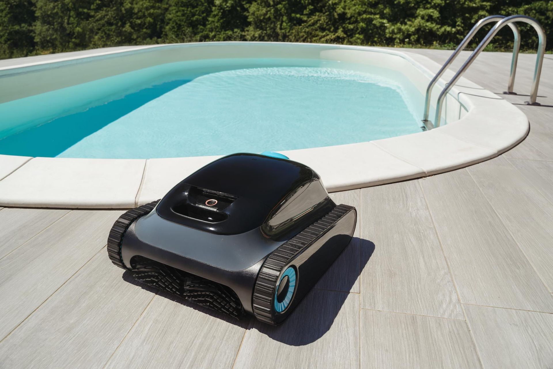 Pool cleaning robot on a deck next to a swimming pool.