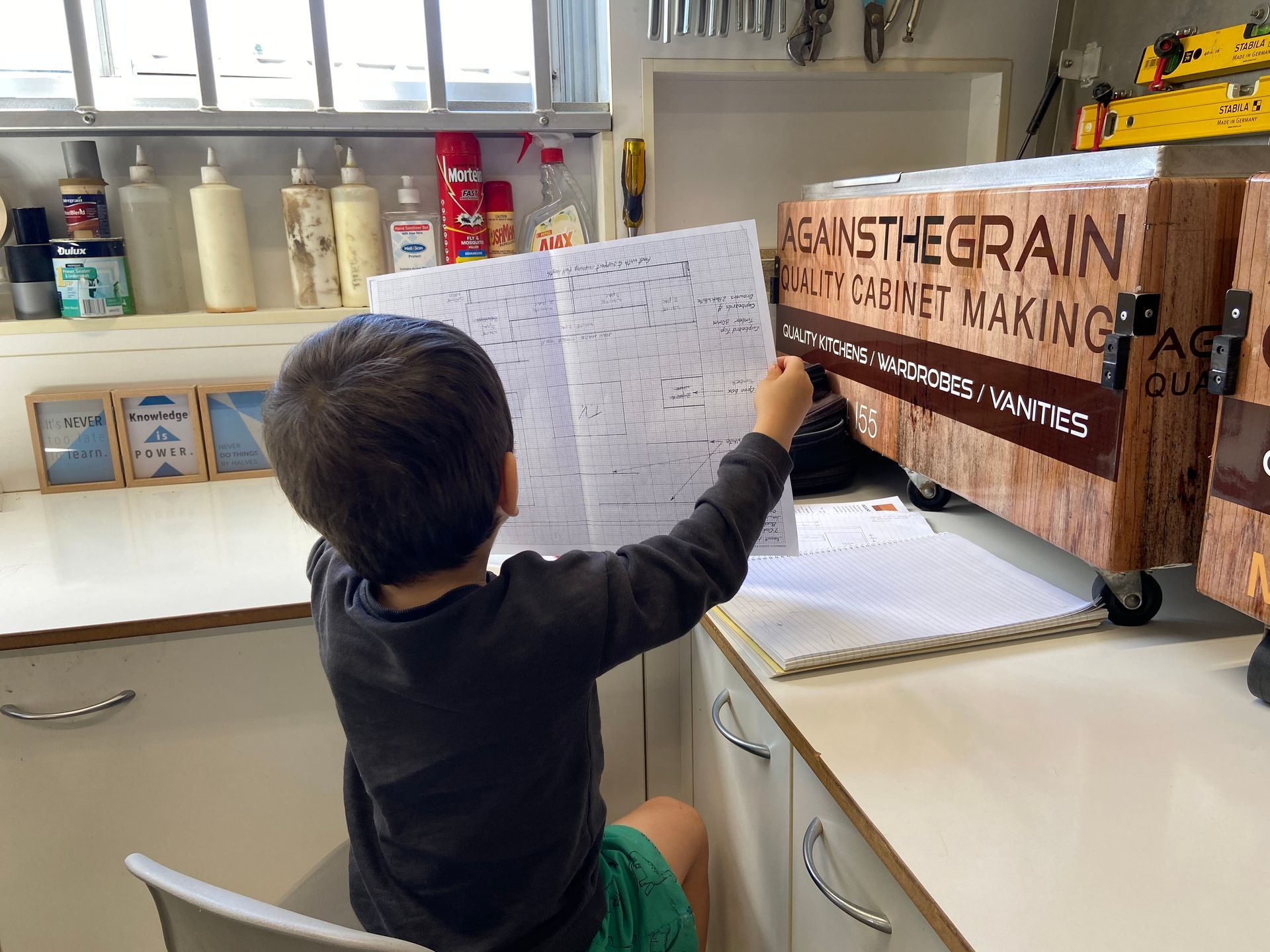 A Kid Looking At the Drawing Sheet Holding in Hands — Residential Cabinetmaking on the Sunshine Coast QLD
