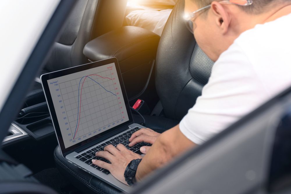 A Man is Sitting in a Car Using a Laptop Computer — Dynamic Performance Systems in Swan Hill, VIC