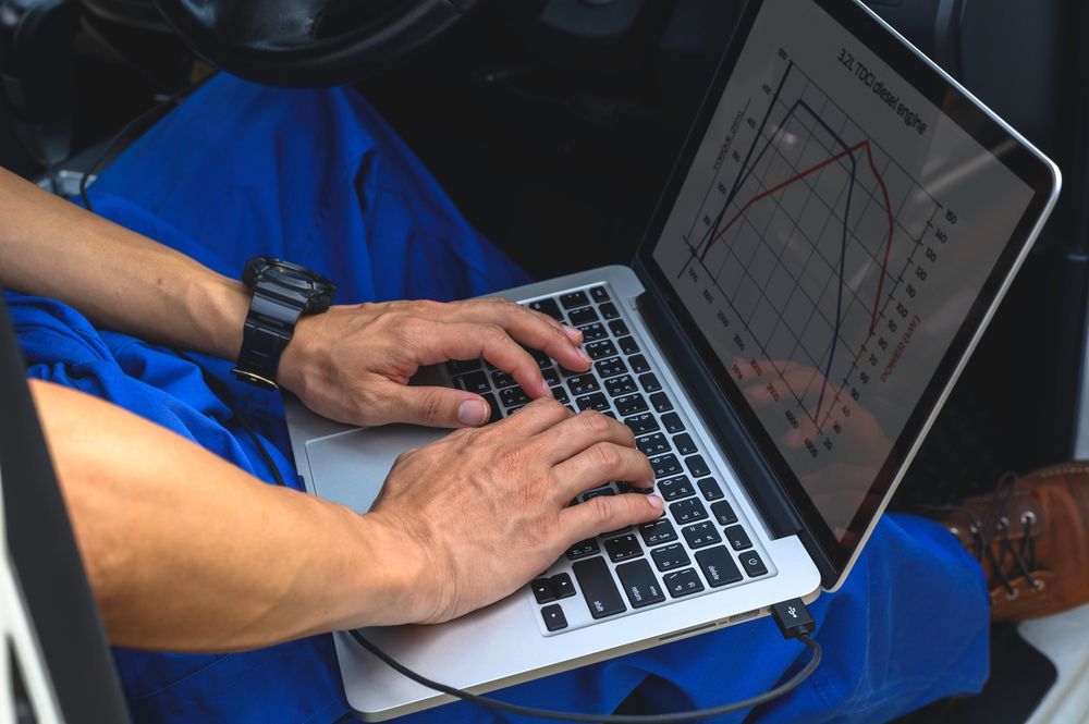 A Man is Sitting in a Car Using a Laptop Computer — Dynamic Performance Systems in Kingaroy, QLD