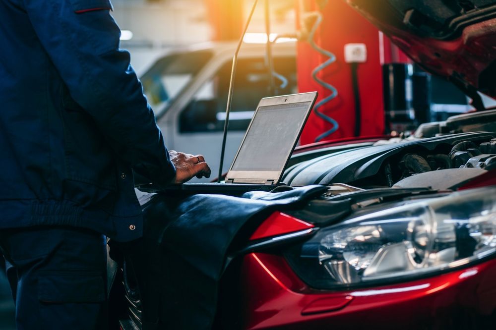 A Mechanic is Using a Laptop Computer to Check the Engine of a Car — Dynamic Performance Systems in Wagga Wagga, NSW