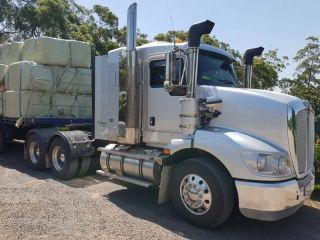 A White Semi Truck is Carrying Bales of Hay on a Trailer — Dynamic Performance Systems In Kelso, NSW