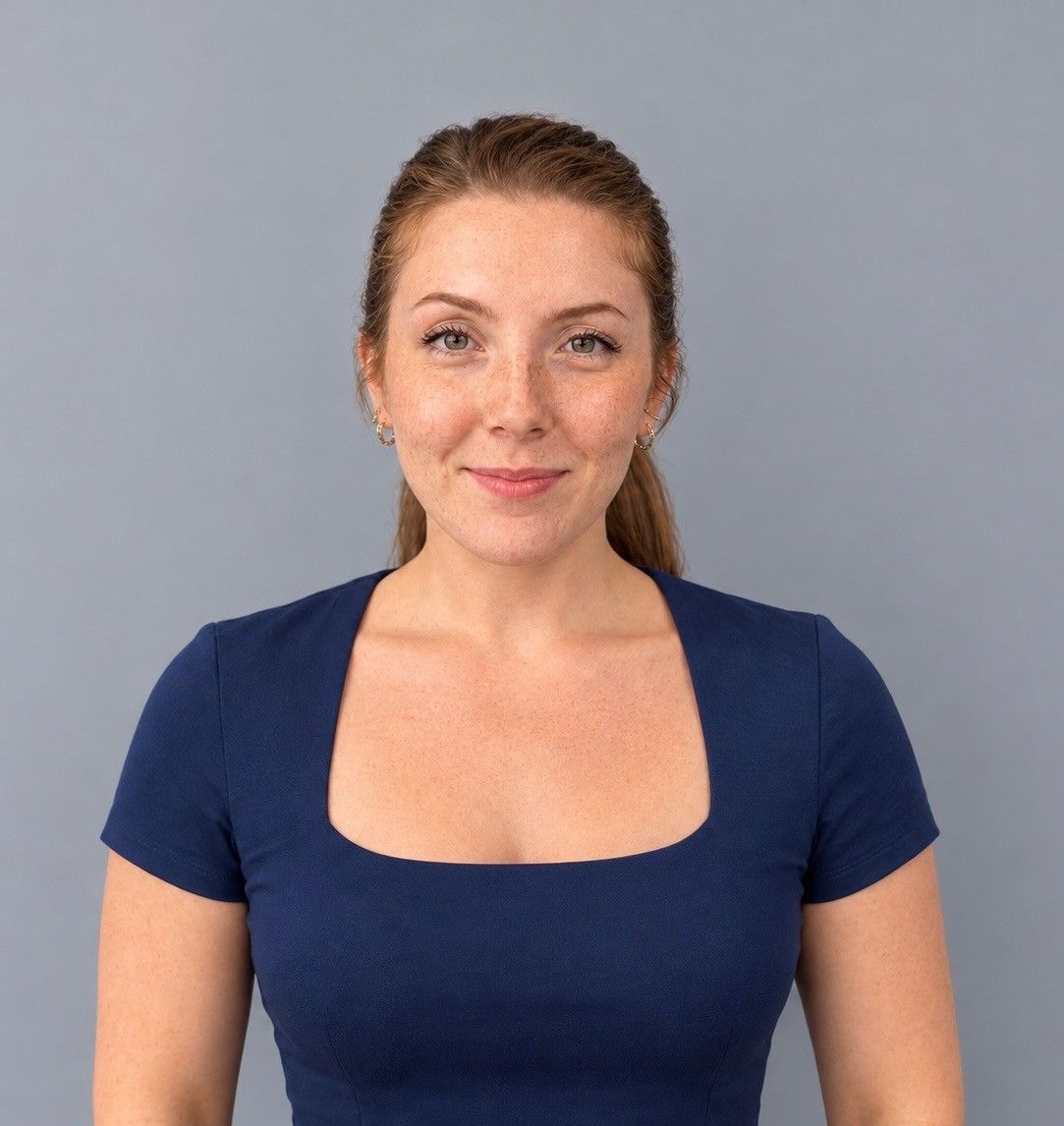 Studio portrait of a woman with braided hair wearing a navy blue top against a gray background