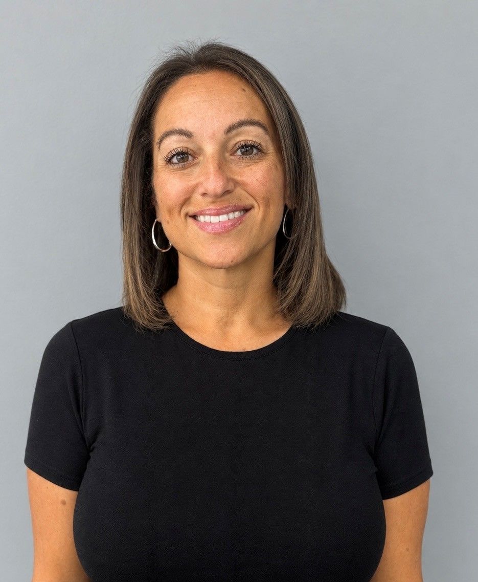 Portrait of a smiling woman in a black shirt against a gray background