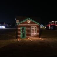 Small holiday-lit house display with green and red lights at night