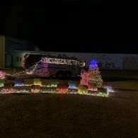 House and yard decorated with colorful Christmas lights at night