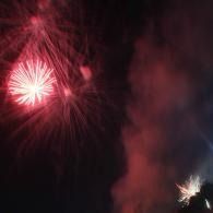 Red and white fireworks bursting against a dark night sky