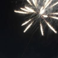 White fireworks bursting against a dark night sky