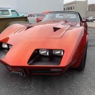 Orange vintage sports car parked outdoors at a car meet, front view