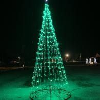 Green-lit cone-shaped light sculpture outdoors at night