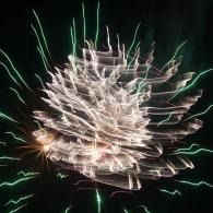 Abstract white and green firework light streaks radiating against a black background