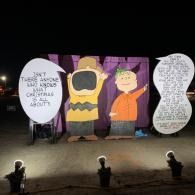 Nighttime sign display with Charlie Brown and Linus with speech bubbles about Christmas time.