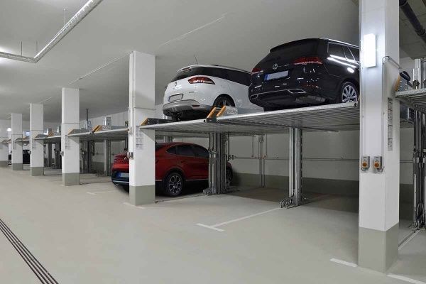 En række biler er parkeret i en parkeringskælder.