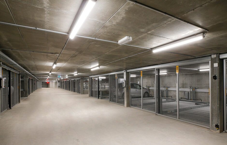 Et stort tomt parkeringshus med biler parkeret deri.