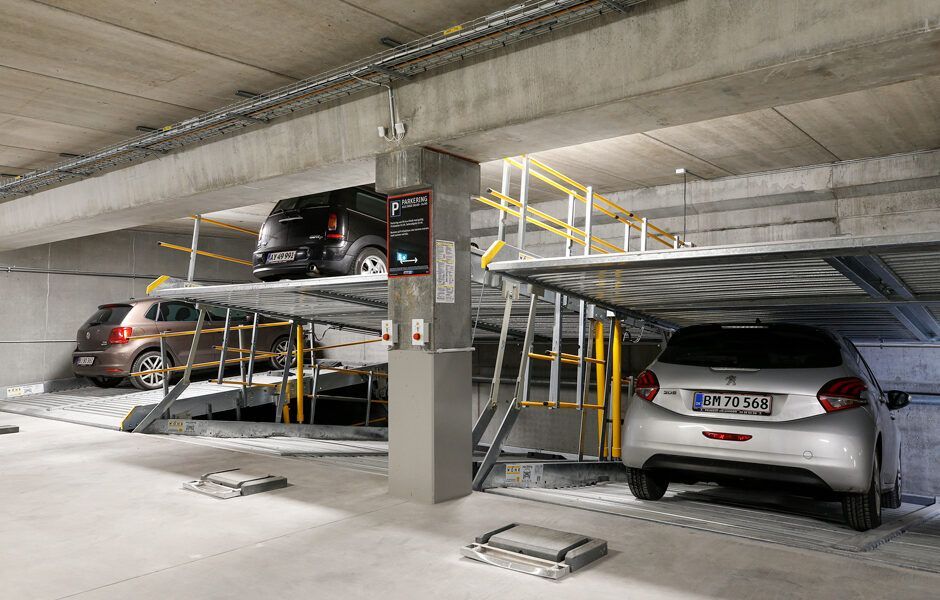 En parkeringskælder med to biler parkeret oven på hinanden.