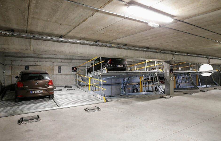En bil er parkeret oven på en anden bil i en parkeringskælder.