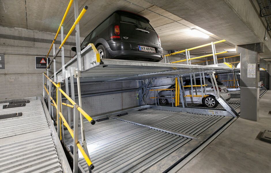 En bil er parkeret oven på en anden bil i en parkeringskælder.